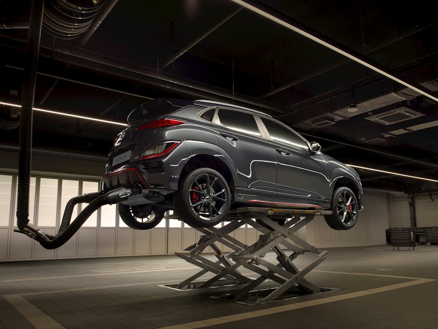 A sleek car on a lift in a high-tech automotive garage.